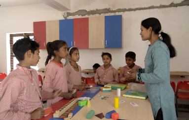 Children studying in a classroom with minimal resources, showcasing the need for educational support.
